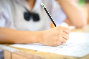 Examination in school concept. student writing answer the question of multiple choice test Examination in school concept. student writing answer the question of multiple choice test