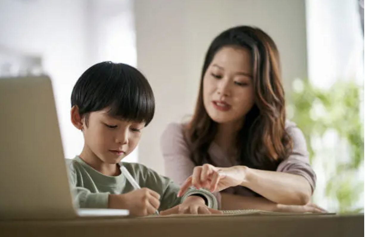 Child practicing Chinese writing on classroom board