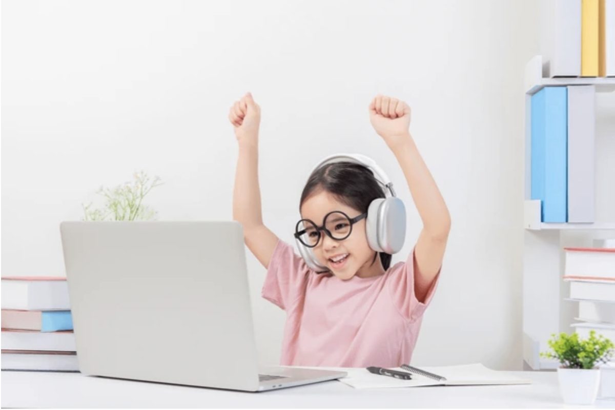 Child studying independently with laptop at desk